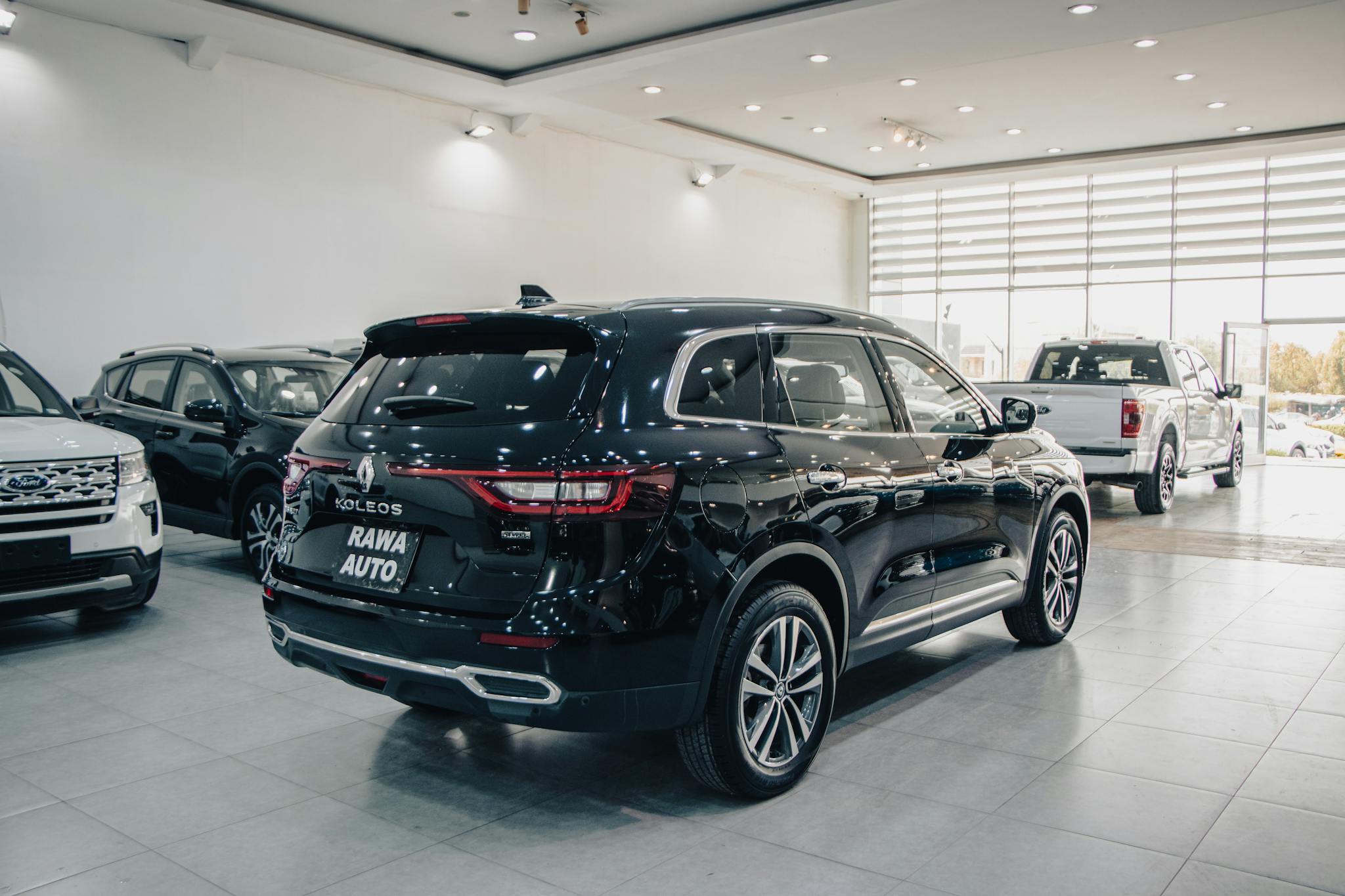 Spacious modern showroom featuring luxury cars on display.